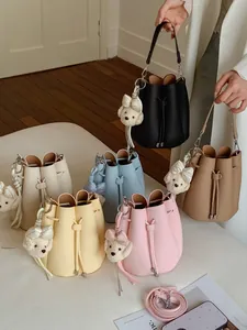 Trendy summer bucket bags for women in multiple pastel colors with cute plush dog charms