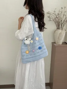 Detaillierte Seitenansicht einer hellblauen handgefertigten Häkeltasche mit Blumen