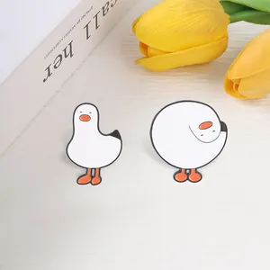 Detailweergave van twee schattige witte gans emaille pinnen voor rugzak en kleding