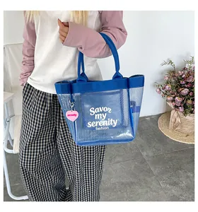 Close-up of a stylish blue transparent mesh tote bag featuring white serenity text detail