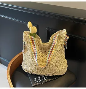 Vue détaillée d'un sac cabas en paille tressée beige fait main avec une bandoulière colorée