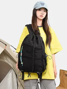 Sac à dos noir à cordon de serrage avec broderie Kleiman dans un décor de camping