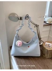 Detalle de bolso de hombro azul con volantes y lindo bordado de fresas.