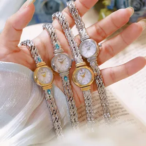 Primer plano de elegantes relojes de pulsera para mujer con circonitas en plata y oro