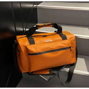 Durable orange travel duffel bag with large capacity and adjustable black shoulder strap