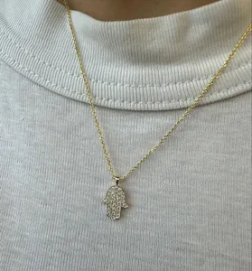Dettaglio ravvicinato di una collana con ciondolo mano di Hamsa in argento S925 e zirconi lucenti