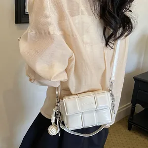 Model wearing a stylish minimalist beige woven small square crossbody bag for women
