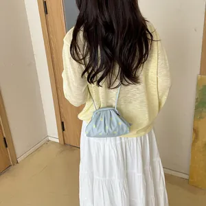 Detailed view of a light blue polka-dot crossbody bag styled with a summer outfit.