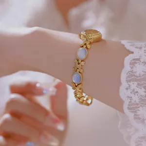 Reloj de pulsera vintage dorado con piedras azules y eslabones de mariposa en encaje