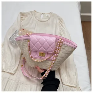 Détail du rabat en cuir matelassé rose et chaîne dorée sur un sac panier en paille
