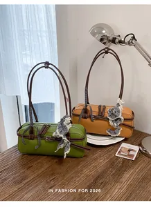 Detailed view of fashionable green and orange Boston shoulder bags with checkered bows.