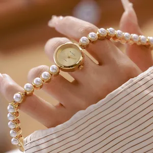 Elegante Nahaufnahme einer Vintage-Luxus-Golduhr mit edlem Perlenarmband für Damen