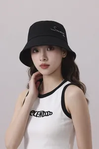 Primer plano de un elegante sombrero de pescador negro con bordado en una modelo