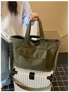 Olive green large capacity canvas tote bag placed on a white suitcase in a travel scene