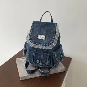Vista dettagliata di uno zaino in denim vintage con bordo in pizzo su un libro d'arte