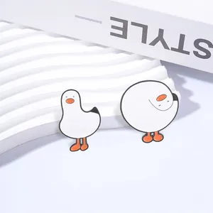 Detailopname van twee schattige cartoon witte gans emaille spelden in verschillende houdingen