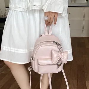 Detailansicht eines stylischen rosa Mini-Rucksacks mit dekorativer Schleife und Herz