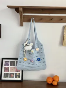 Detailansicht der hellblauen, gehäkelten Tragetasche mit bunten Blumenakzenten