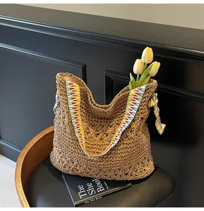 Vue détaillée d'un sac cabas en paille marron tissé main avec bandoulière à motifs colorés