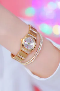 Detailopname van elegant goudkleurig horloge met strassteentjes en bijpassende armband