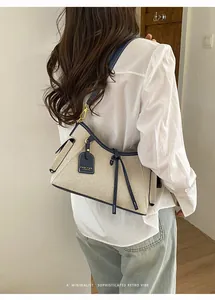 Mujer elegante con bolso de lona beige y azul marino y una camisa blanca