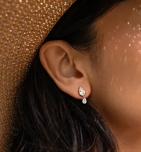 Close-up detail showing elegant gold waterdrop zircon stud earrings worn by a model
