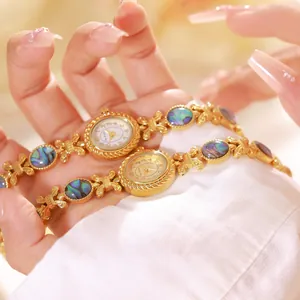 Primer plano de lujosos relojes de pulsera dorados con incrustaciones de concha abulón.