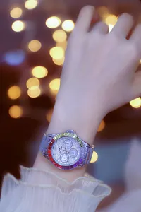 Close-up of luxury women's silver watch with rainbow crystal bezel and iced-out dial