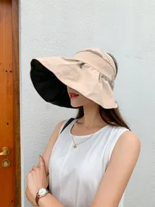 Close-up of a women's large brim beige sun hat with black UV coating