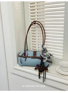 Detail shot of light blue Boston bag with brown straps and cute dachshund charm.