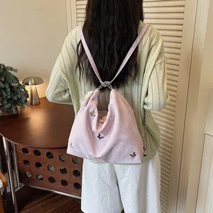 Pink multifunctional backpack with butterfly details shown in a cozy lifestyle setting