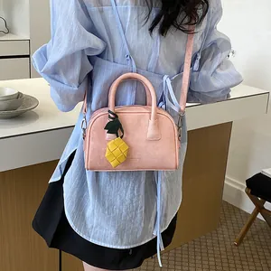 Stylish pink pillow bag for women featuring a cute yellow woven pineapple charm detail