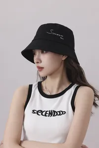 Modelo asiática luciendo un gorro de pescador negro de estilo japonés para el verano.