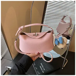 Detailed view of pink pebble grain bucket bag with pearl and bear charm accessories