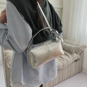 Stylish silver metallic pillow bag for women worn as a versatile shoulder bag