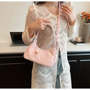 Detailed shot of a pink floral jacquard underarm bag in a chic, minimalist office setting.