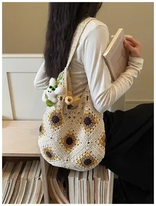 Primo piano della borsa tote all'uncinetto con girasoli indossata da una modella fiera.