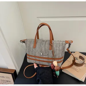 Detailed view of a retro woven bucket bag featuring chain accents and a colorful bead tassel