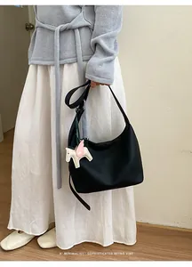 Black leather hobo shoulder bag detail, minimalist design, versatile casual commuter bag.