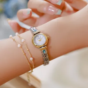 Primer plano de un elegante reloj de mujer con circón azul y pulsera de perlas