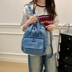 Eine Detailansicht eines blauen Denim-Rucksacks, der als trendige Umhängetasche dient.