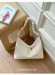 Bolso de hombro plisado blanco crema con bordado de fresas en un acogedor interior