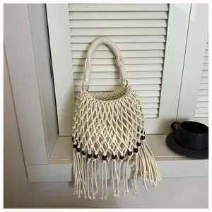 Detail shot of off-white macramé bucket bag with elegant tassels and wooden beads