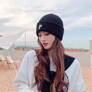 Asian woman wearing a black Korean style knitted beanie with white P letter embroidery