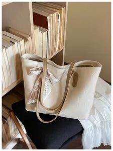 Elegant beige tote bag with geometric rhombic pattern and scarf detail in a lifestyle setting