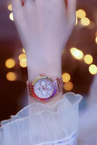 Macro shot of a rose gold women's watch featuring a rainbow gradient gemstone bezel on wrist