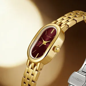 Detail einer luxuriösen Vintage-Uhr mit bordeauxrotem ovalem Zifferblatt und Goldband