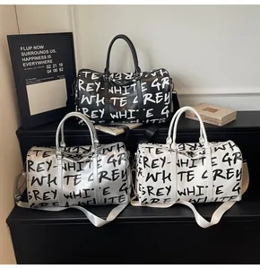 Three stylish duffle bags in black, silver, and white with bold graffiti letter prints.