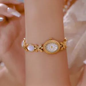 Primer plano de un elegante reloj de pulsera dorado con incrustaciones de nácar
