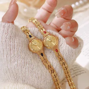 Detalle de relojes de cadena dorada vintage con piedras de circón rojas y azules para mujer